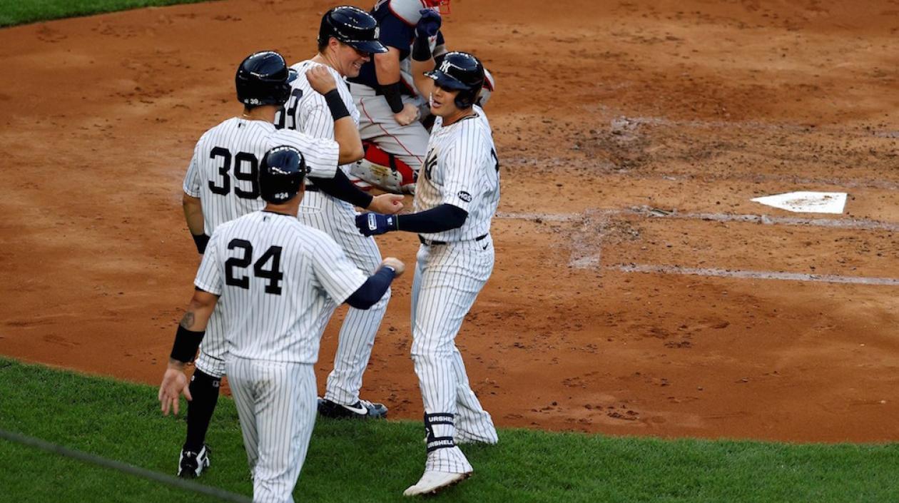 Gio Urshela felicitado por sus compañeros tras conectar el Grand Slam.