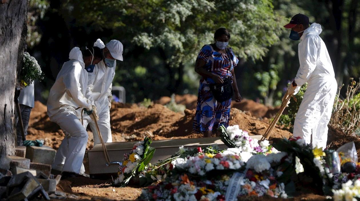 Empleados cargan el ataúd de una persona que murió por Covid-19 en el cementerio de Vila Formosa en Sao Paulo (Brasil).