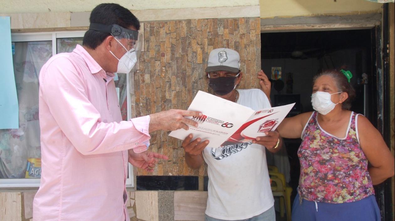 Entrega de título a una familia beneficiaria.