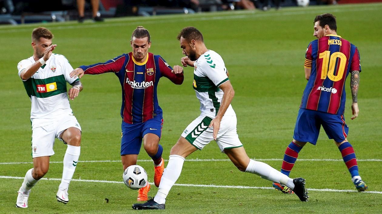 El delantero argentino del FC Barcelona Lionel Messi (dcha) y el francés Antoine Griezmann (2i) pelean por el control del balón.