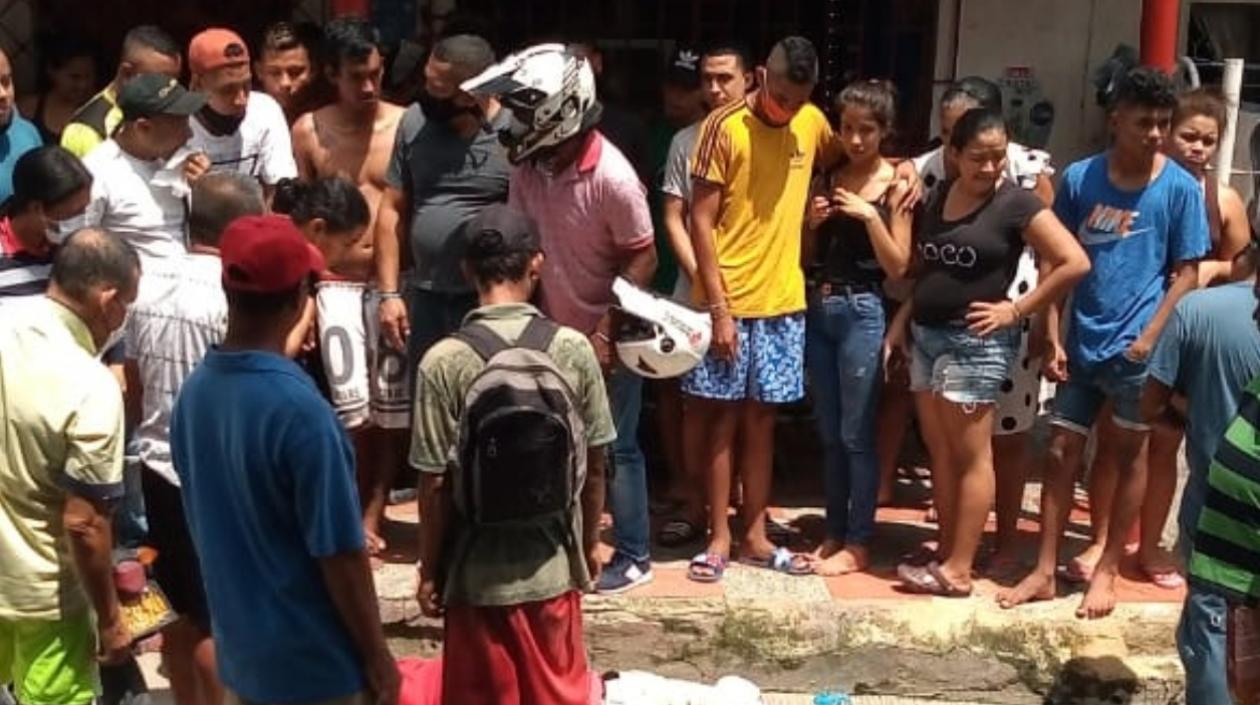 Las personas se aglomeraron alrededor del cuerpo del hombre que fue asesinado en el sitio. 