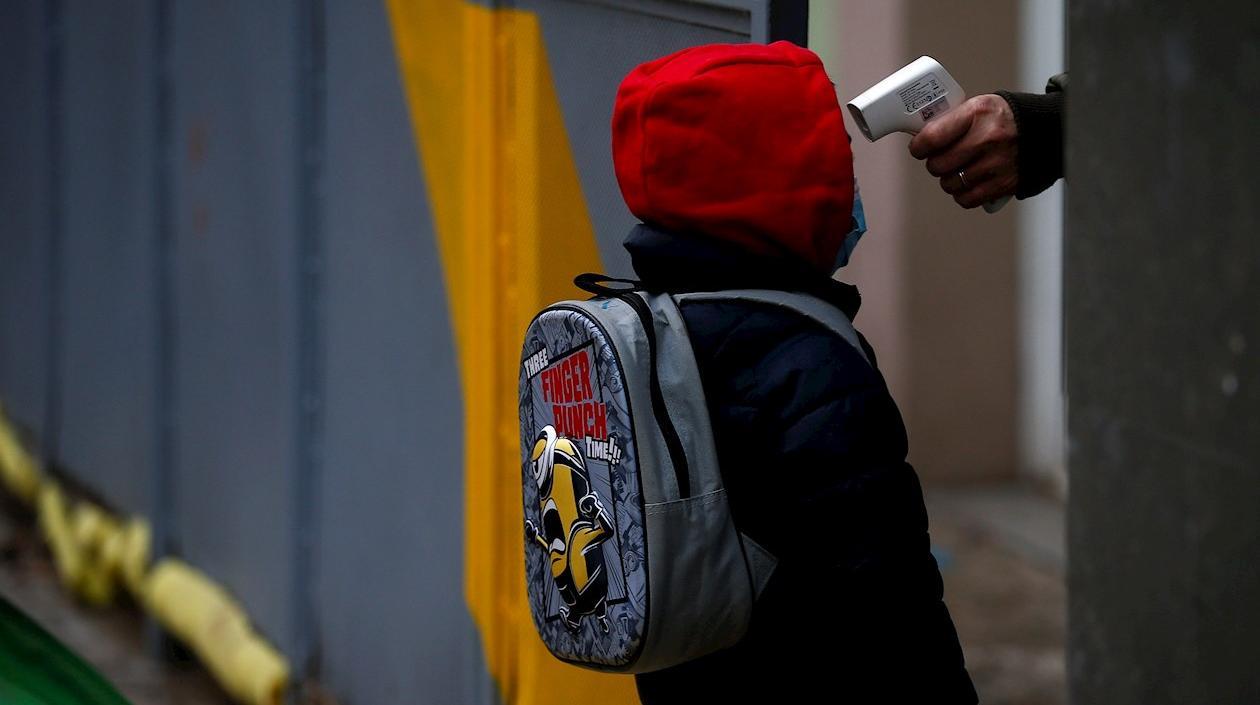Una profesora toma la temperatura a un alumno de la Escuela Rubén Dario de Barcelona antes de entrar a clase. 