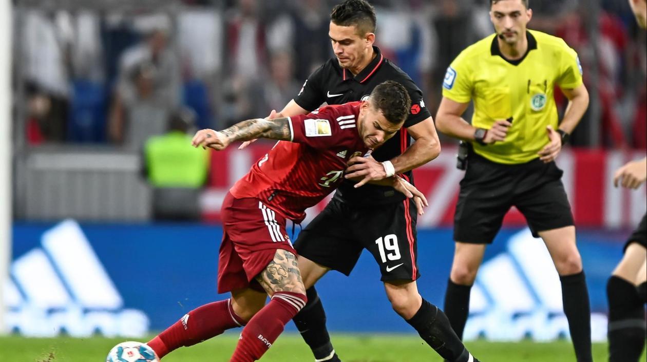 Rafael Santos Borré disputa la pelota con Lucas Hernández. 