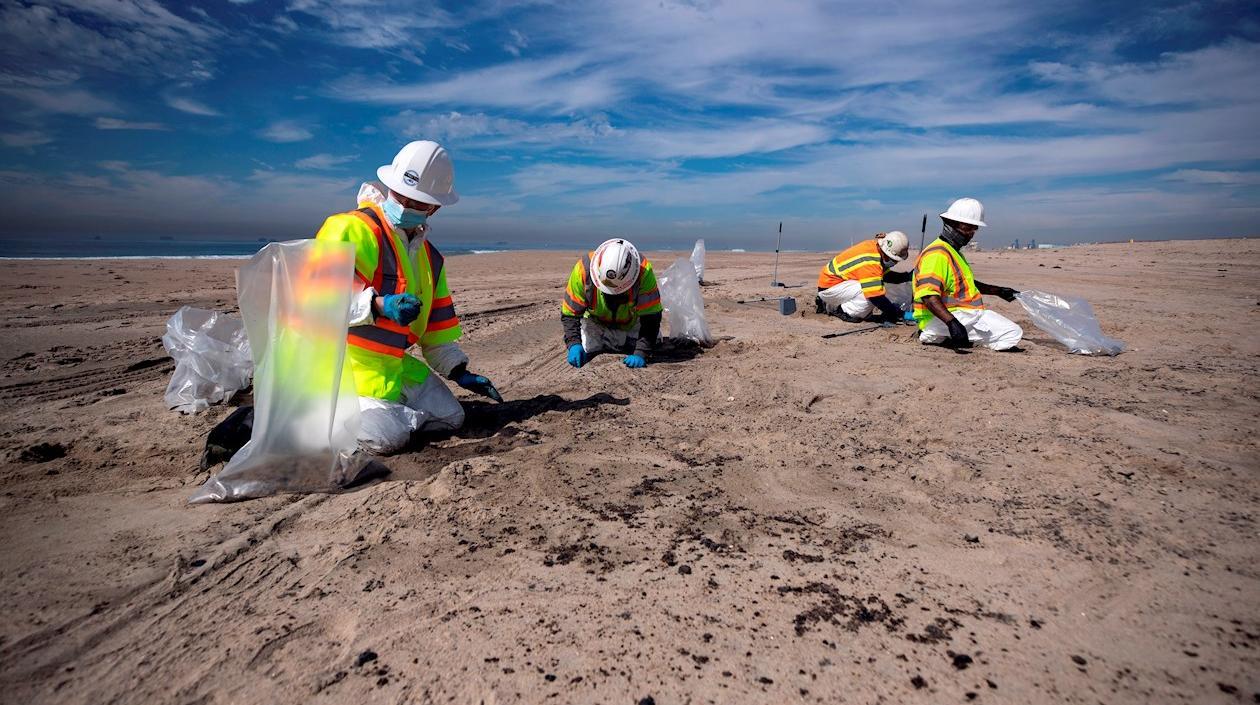 Las cuadrillas recogen el alquitrán de la playa después de un derrame de petróleo frente a la costa de Huntington Beach, California, EE. UU.