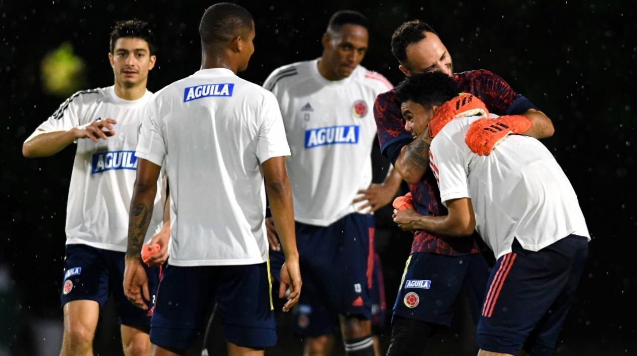 David Ospina juega con Luis Díaz, ante la mirada de sus compañeros. 