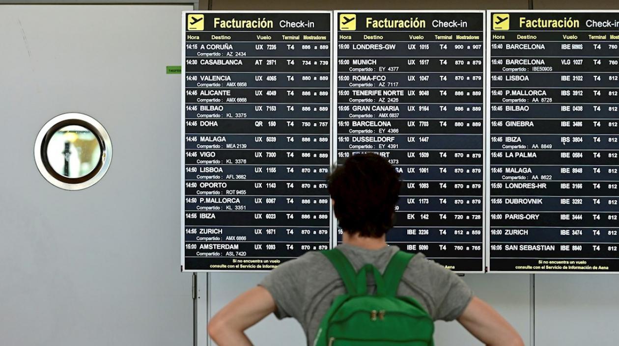 Un pasajero comprueba un panel de información sobre vuelos en la terminal 4 del aeropuerto Adolfo Suárez-Barajas en Madrid, en una imagen de archivo. 