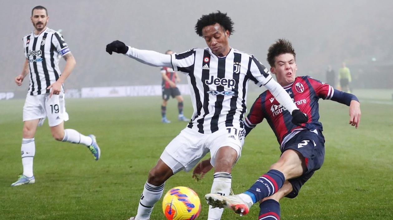 Juan Guillermo Cuadrado disputando el balón con Aaron Hickey.