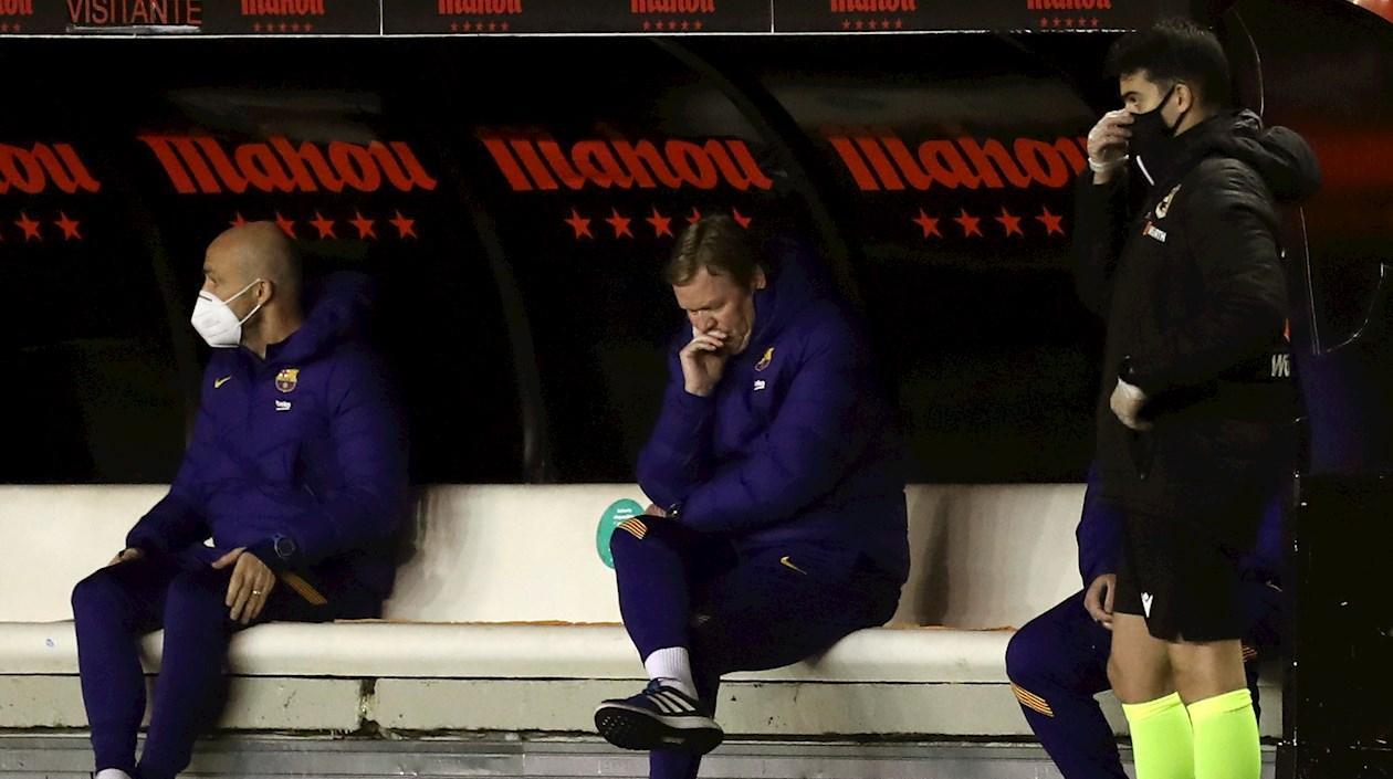 Ronald Koeman medita en el banco durante un partido. 