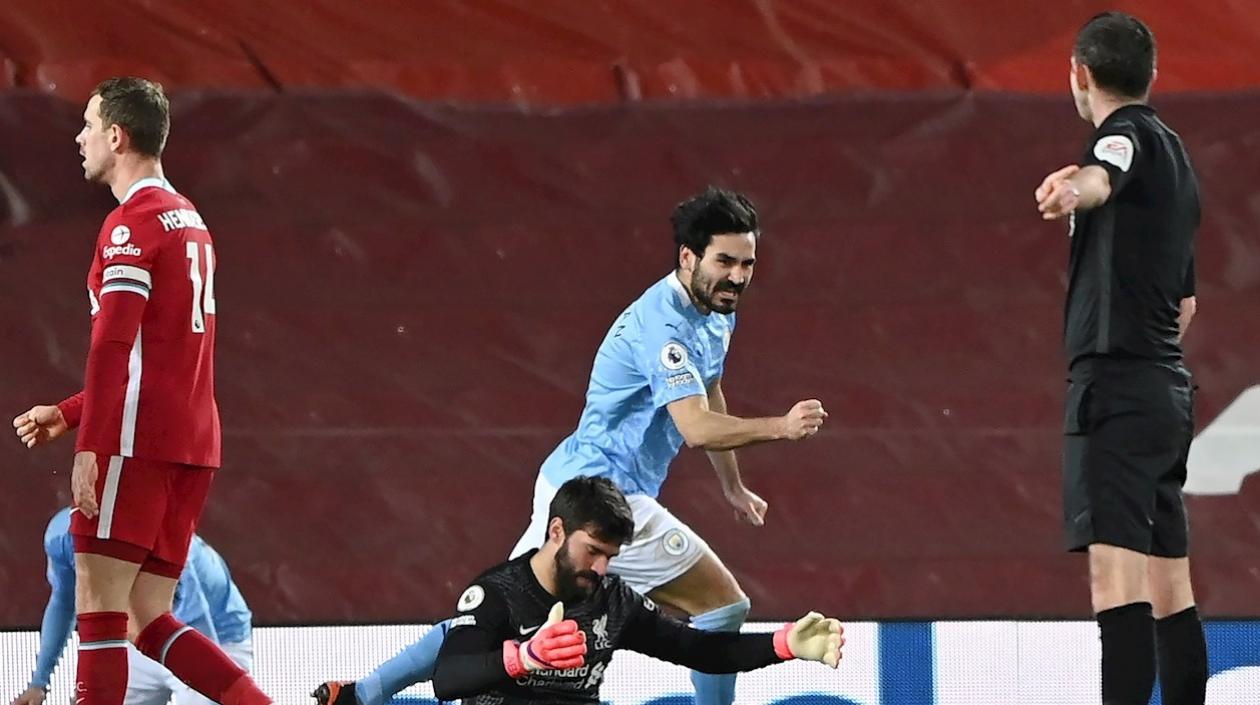 Ilkay Guendogan celebra ante la lamentación de Alisson. 