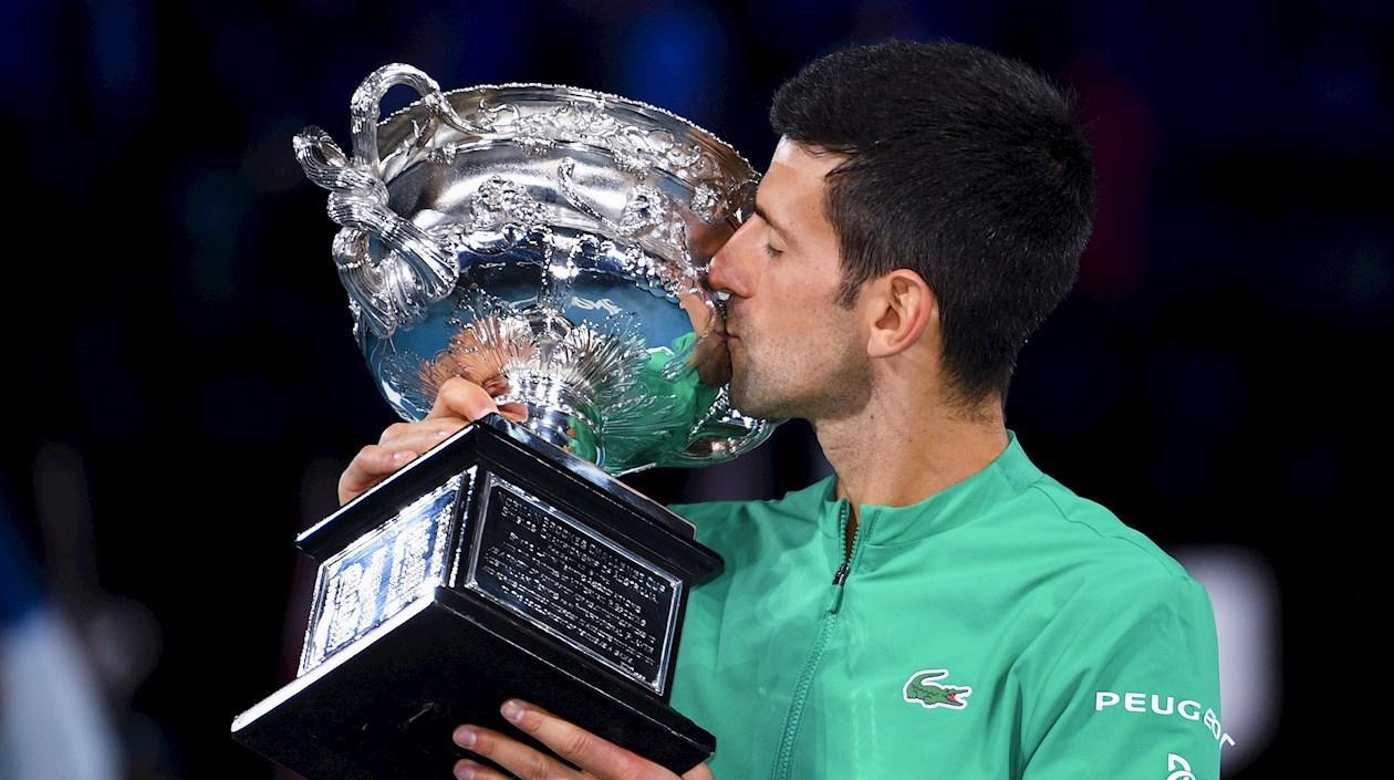 El serbio Novak Djokovic besa el trofeo al ganar el Abierto de Australia. 