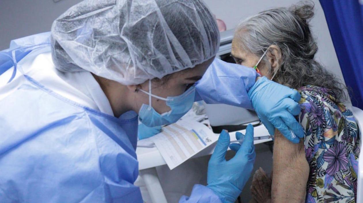 Aplicación de la vacuna a uno de los adultos mayores.