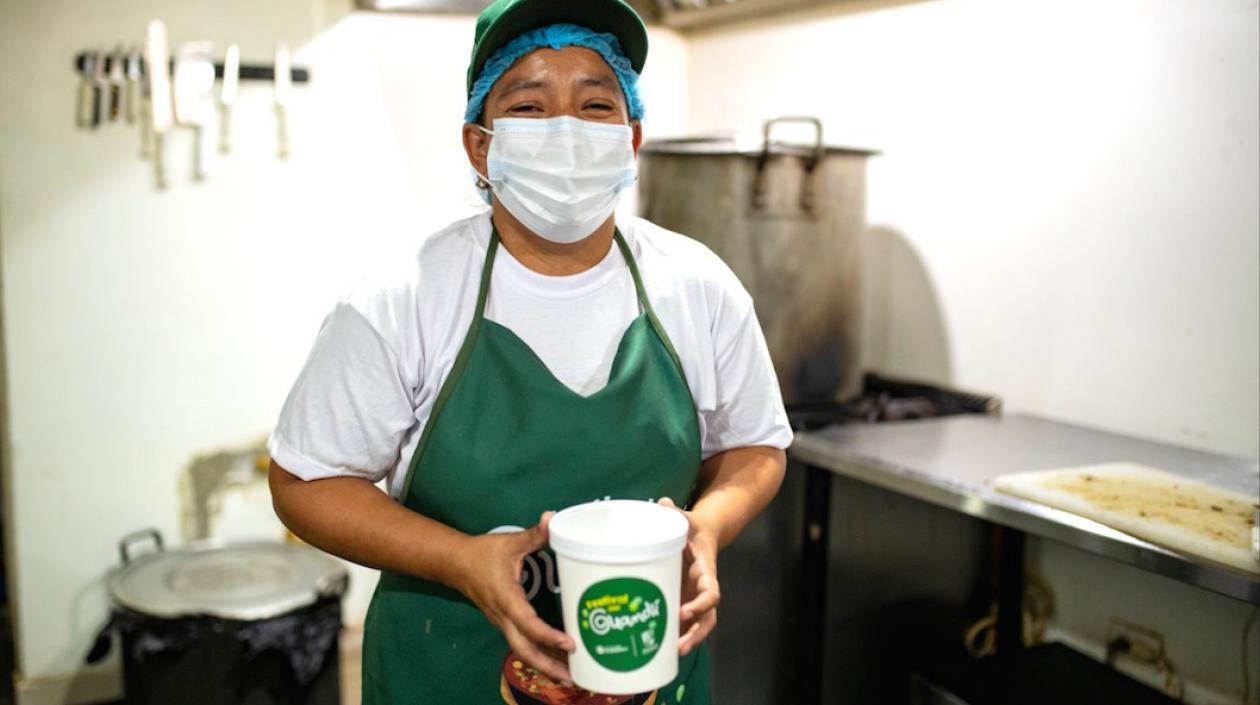 Una matrona exhibiendo una porción del sancocho.