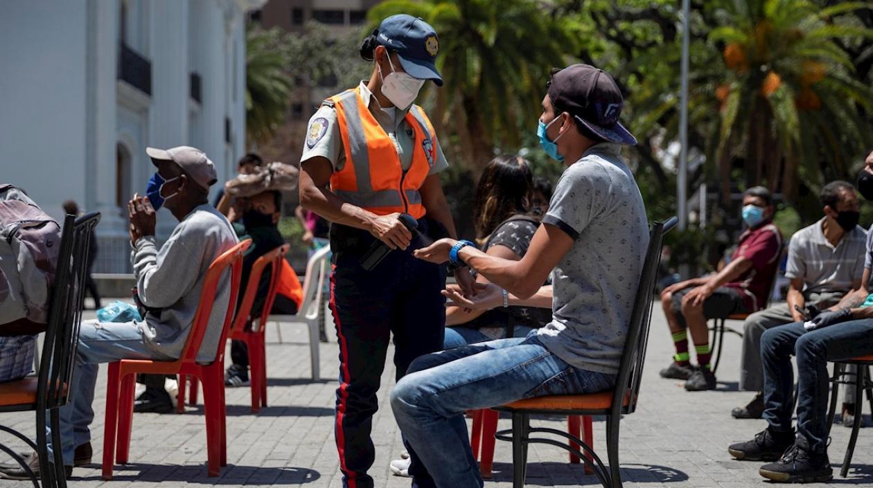 Un policía habla con un joven sancionado por incumplir las medidas que buscan controlar el coronavirus.