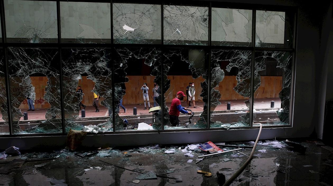 Manifestantes destruyen locales comerciales y bancarios durante las protestas contra la reforma tributaria.
