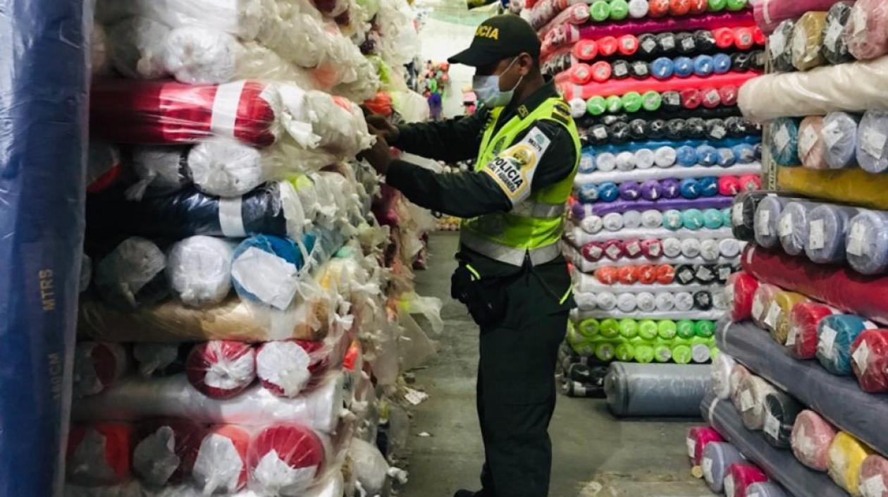 Un uniformado de la Polfa revisa mercancía en un local comercial.