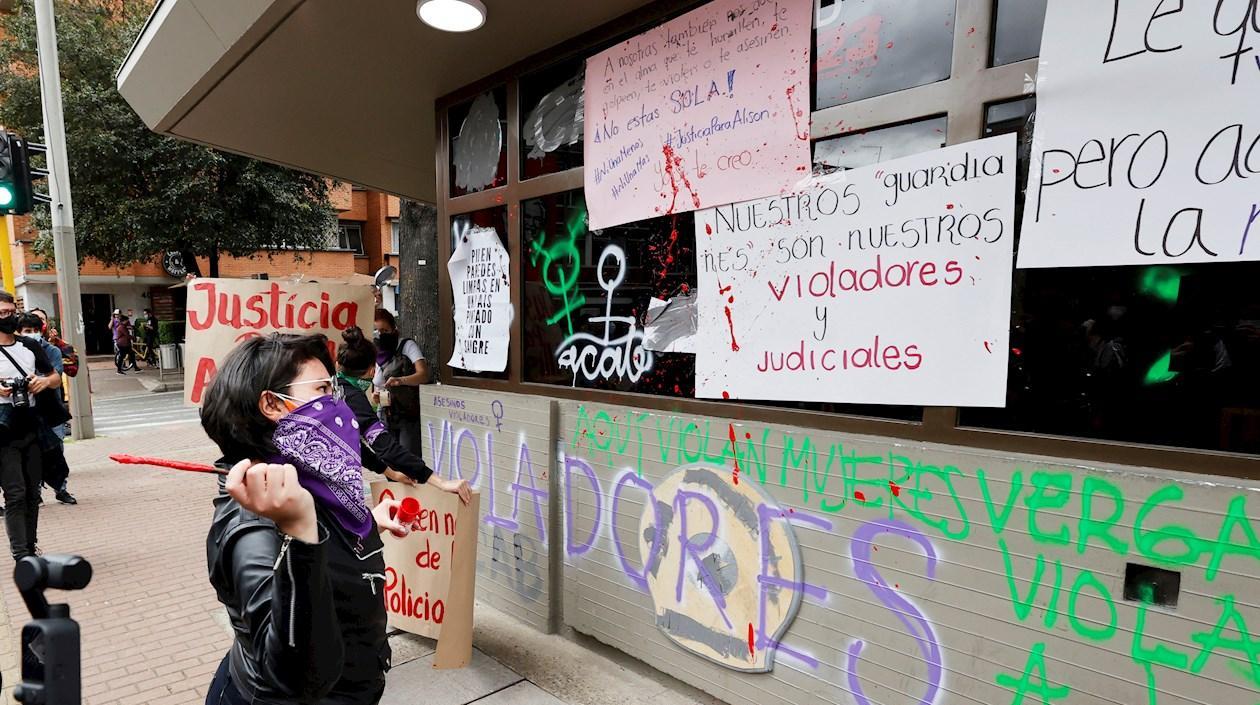 Una mujer lanza pintura sobre las paredes de un Comando de Atención Inmediata (CAI) de la Policía.