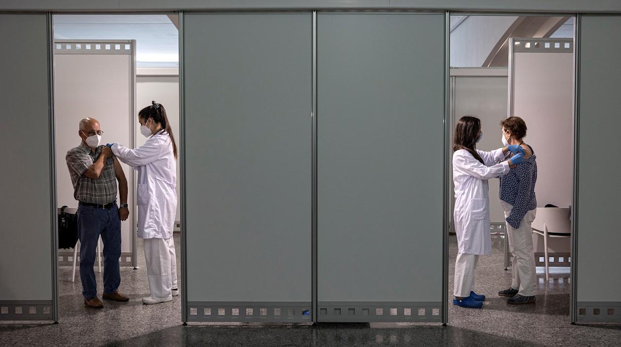 Dos personas de entre 66 y 69 años en España reciben la segunda dosis de la vacuna contra el Covid-19 de Pfizer.