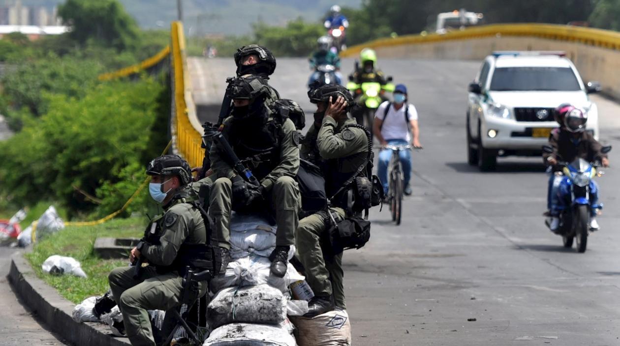 Policías vigilan la vía "Paso del Comercio", recientemente desbloqueada en Cali.