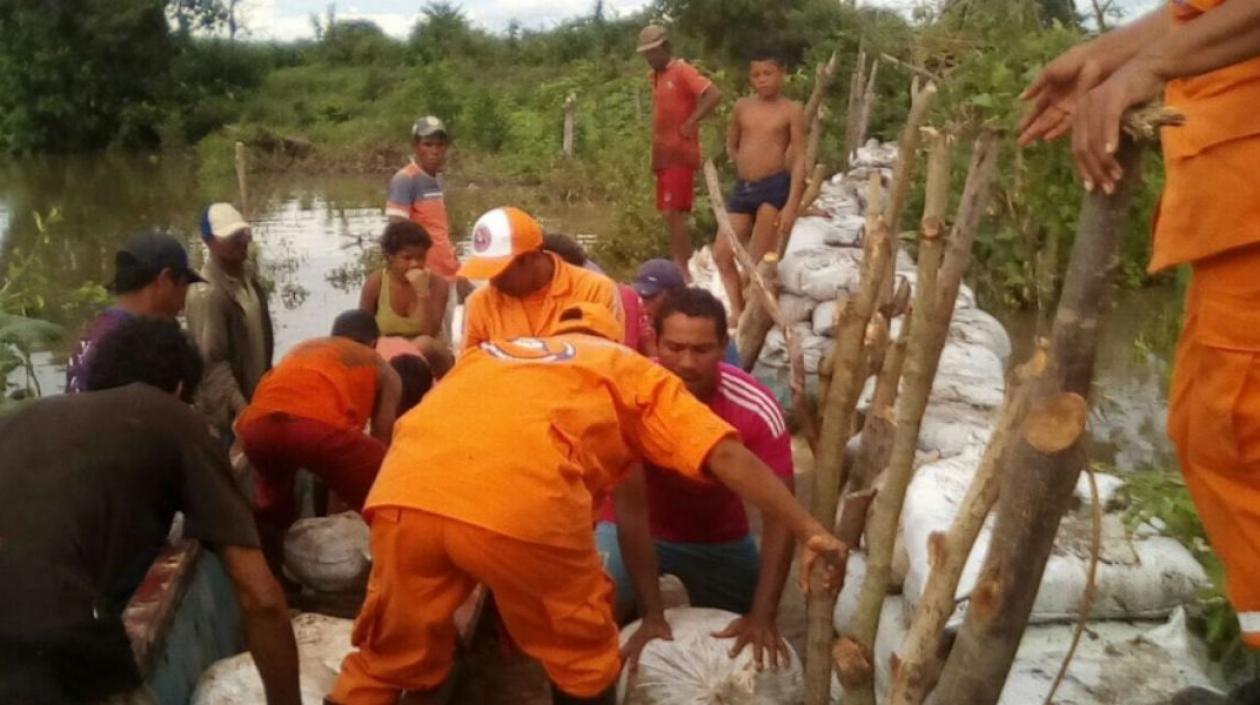 Los organismos de socorro y la comunidad se encuentran en el lugar donde podría desbordarse el río. 