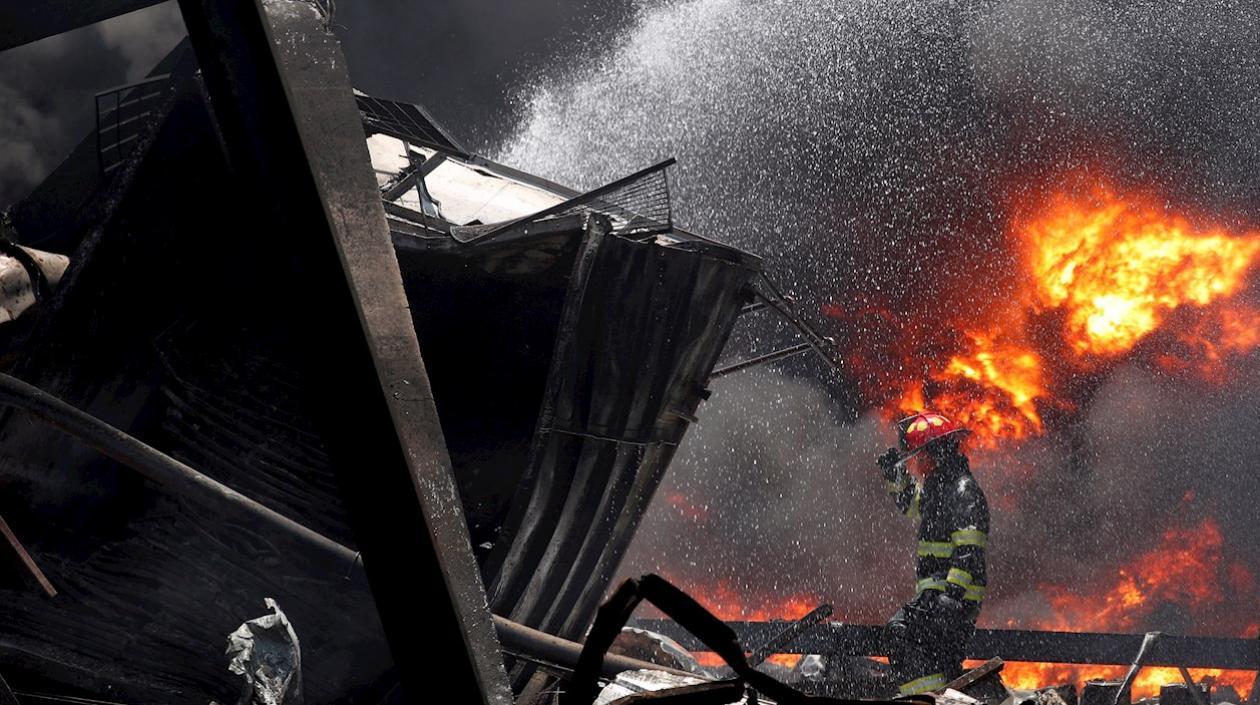 Un bombero tailandés extingue un incendio causado por una explosión en una fábrica de productos químicos de Ming Dih, en Tailandia.