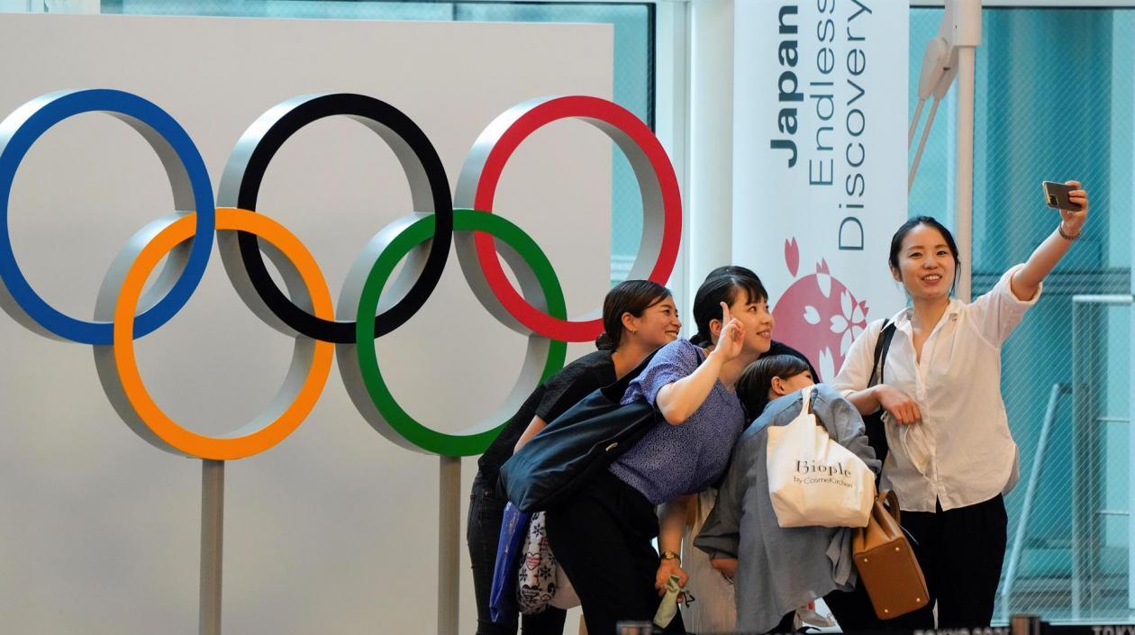 Aficionadas japonesas se toman fotografías con los aros olímpicos. 