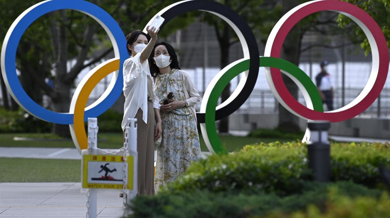 Ciudadanas de Tokio se toman fotografías en los aros olímpicos. 