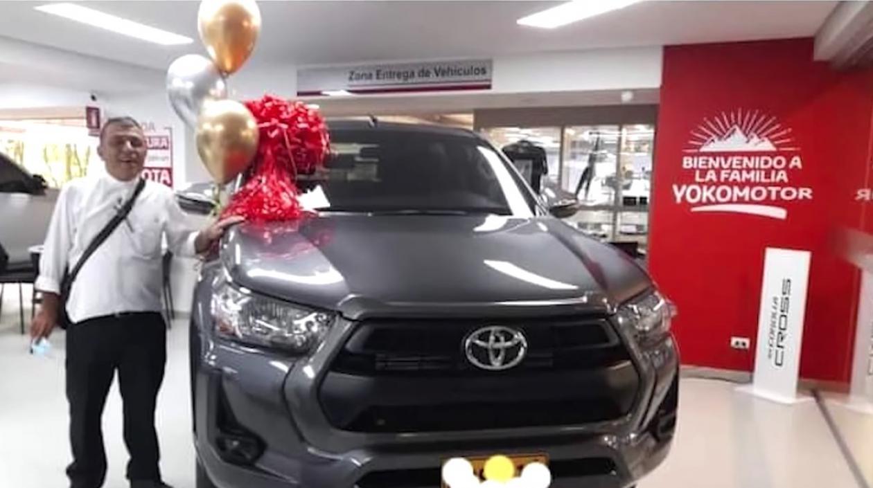 El sacerdote al lado de la lujosa camioneta.