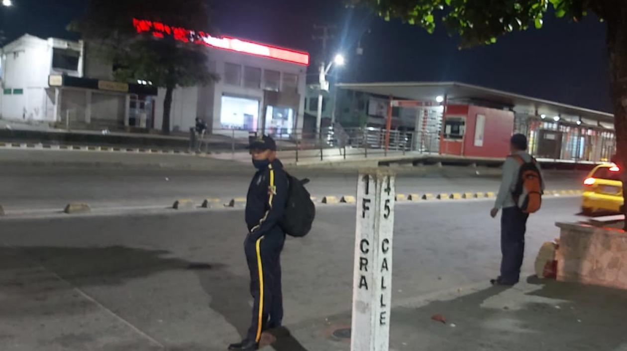 Estación de Transmetro desolada y pasajeros esperando transporte.