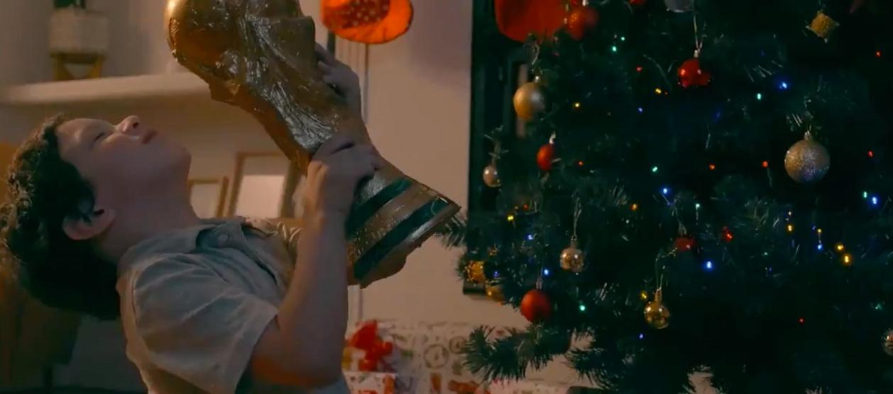 La imagen del niño con la réplica del trofeo de los campeones mundiales.