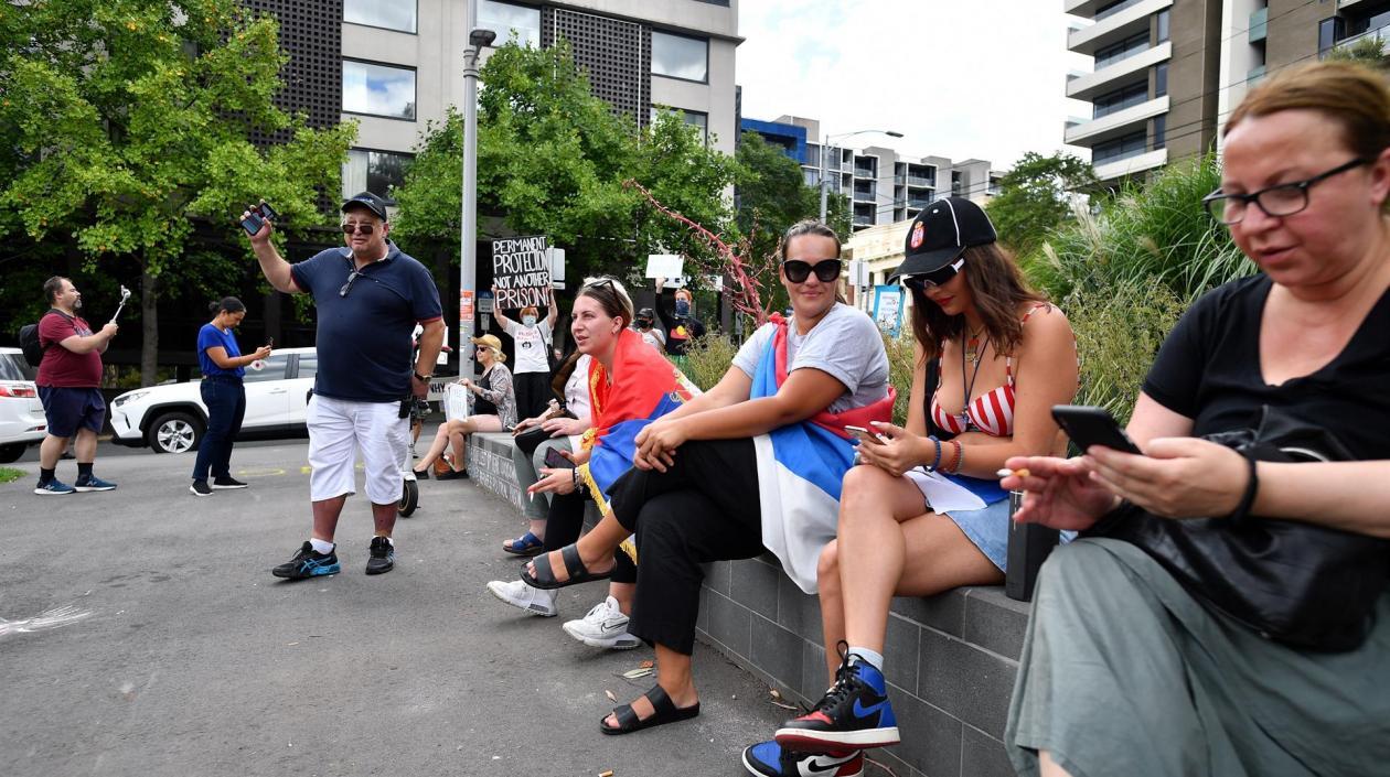 Aficionados de Novak Djokovic lo acompañan desde las afueras.