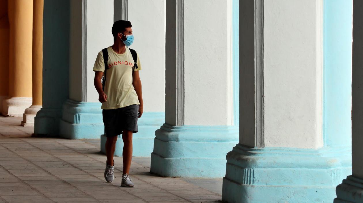 Hombre camina con tapabocas para prevenir contagios. 