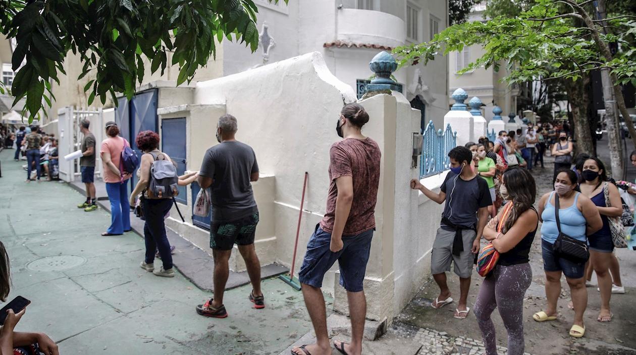 Decenas de personas hacen fila para tomarse una prueba de detección de coronavirus.