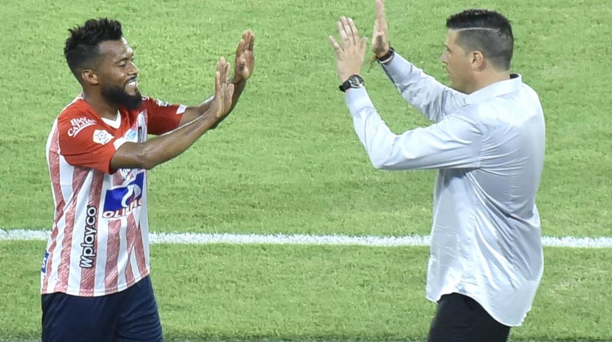 El Dt Juan Cruz Real celebrando con la figura del partido, Luis 'Cariaco' González.