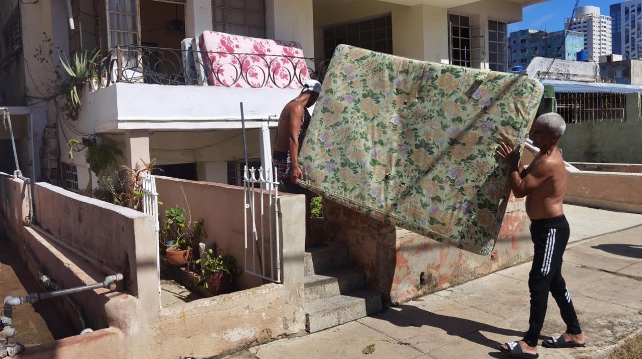   Varias personas sacan a la calle sus pertenencias tras el paso del huracán Ian en La Habana.
