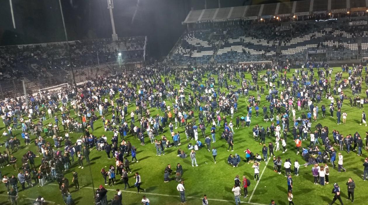 Hinchas en el terreno de juego de la cancha de Gimnasia y Esgrima de La Plata.