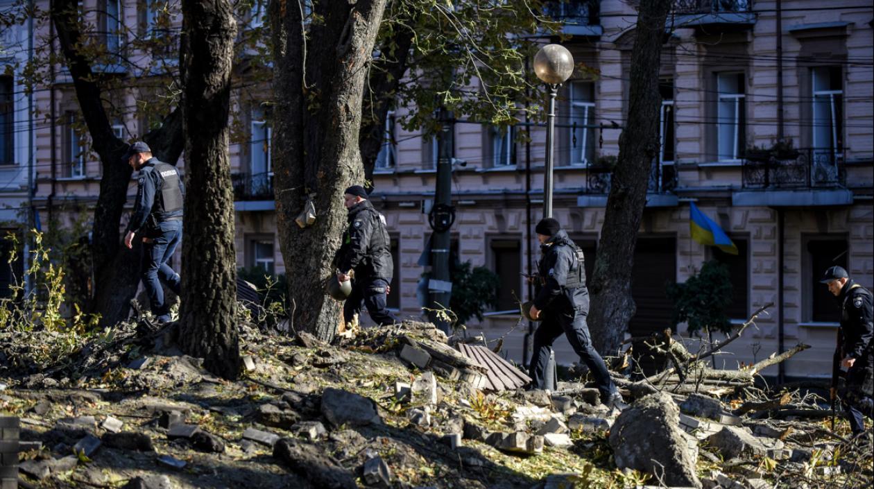 Agentes de policía caminan entre los escombros tras un bombardeo en el centro de Kiev este lunes. 