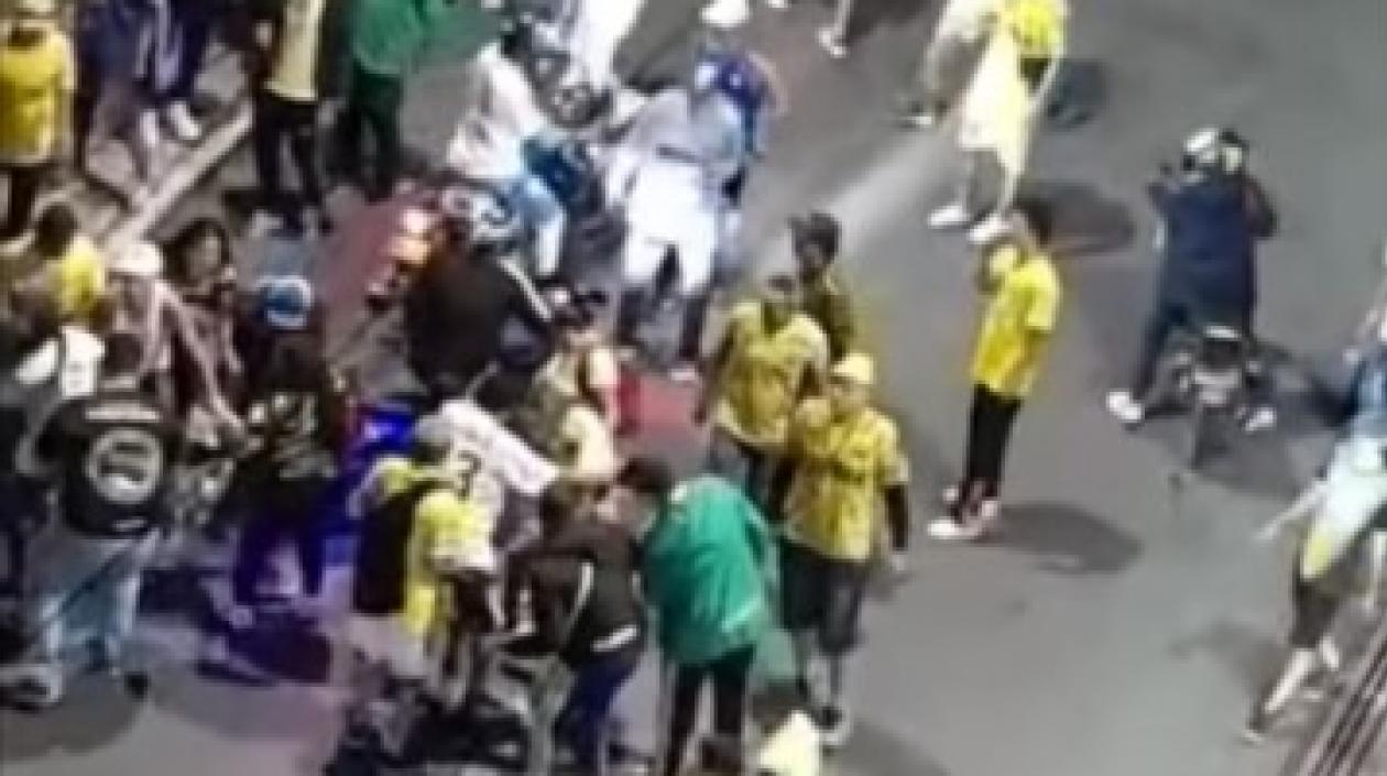 Varias personas auxilian al hincha del Atlético Bucaramanga herido a bala.