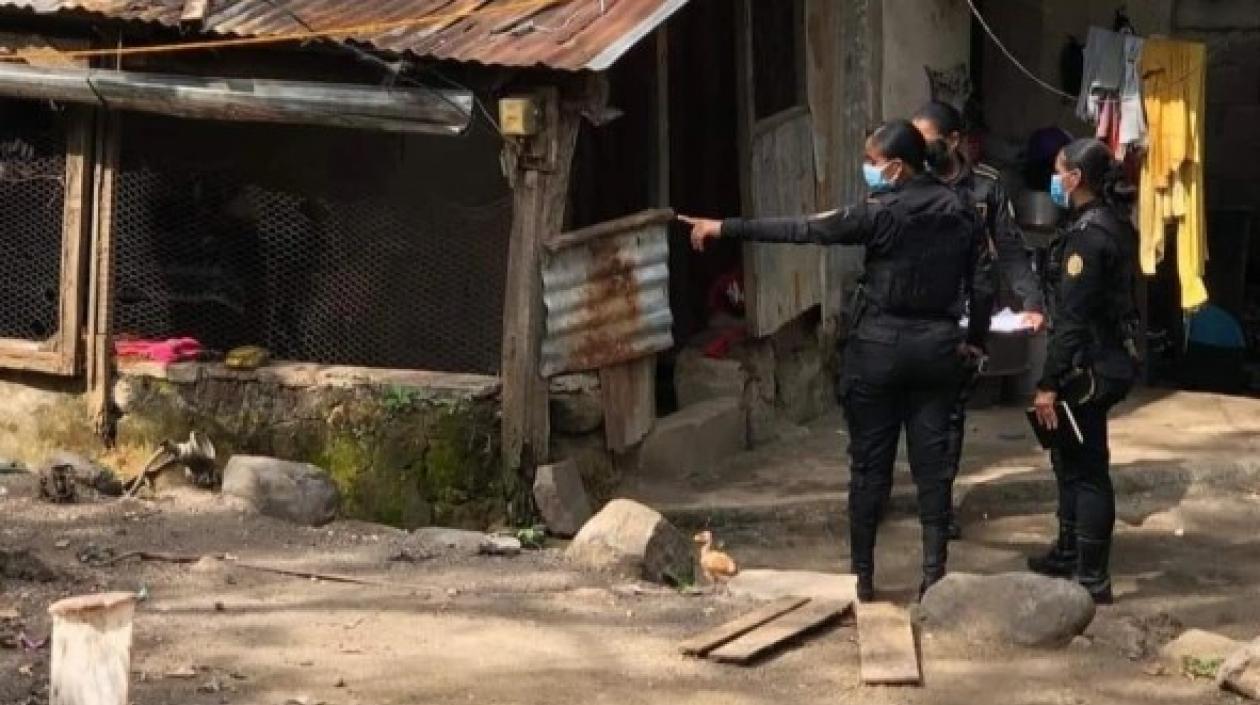 Dos mujeres policías señalan la vivienda en el que fueron hallados los siete cuerpo