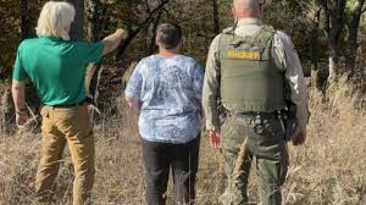 Lucy Studey junto con el adiestrador de perros de cadáveres.