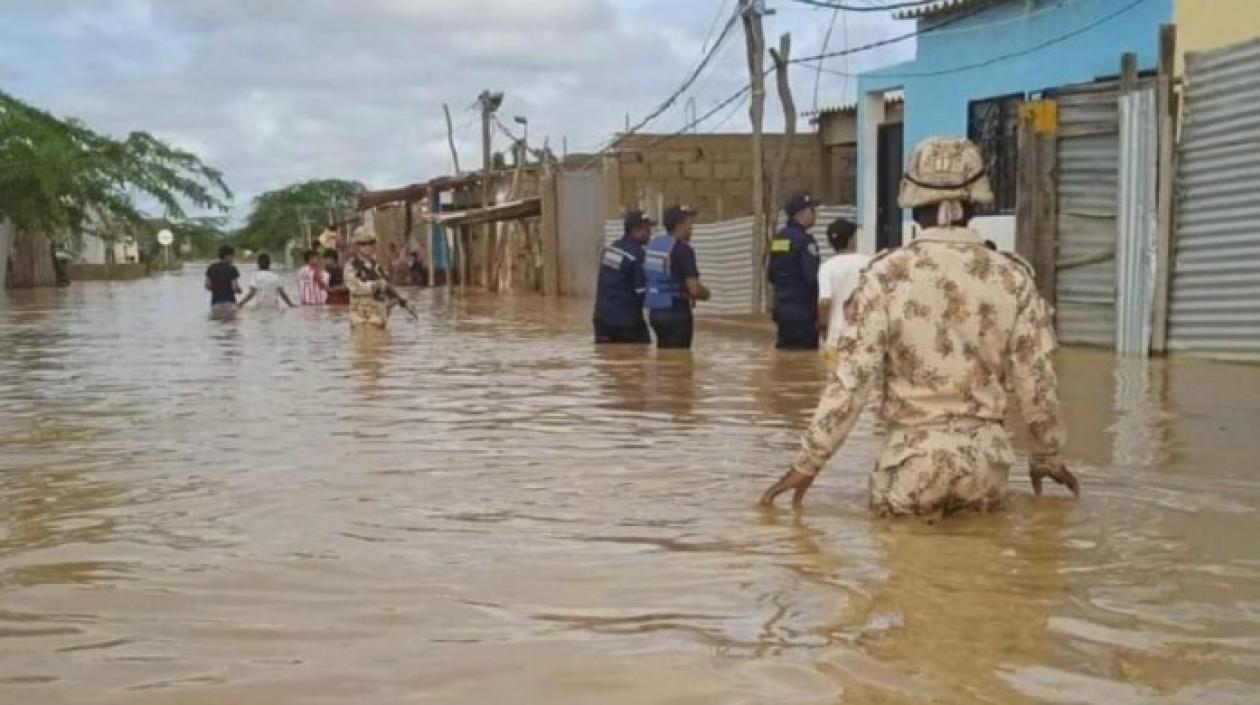 Organismos de socorro y soldados caminan entre las aguas desbordadas de Uribia, en La Guajira.