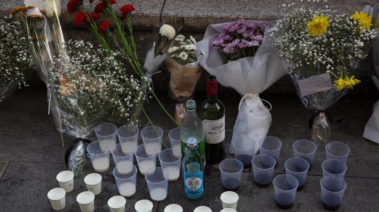 Personas dejan flores en la calle de Seúl donde ocurrió la estampida.
