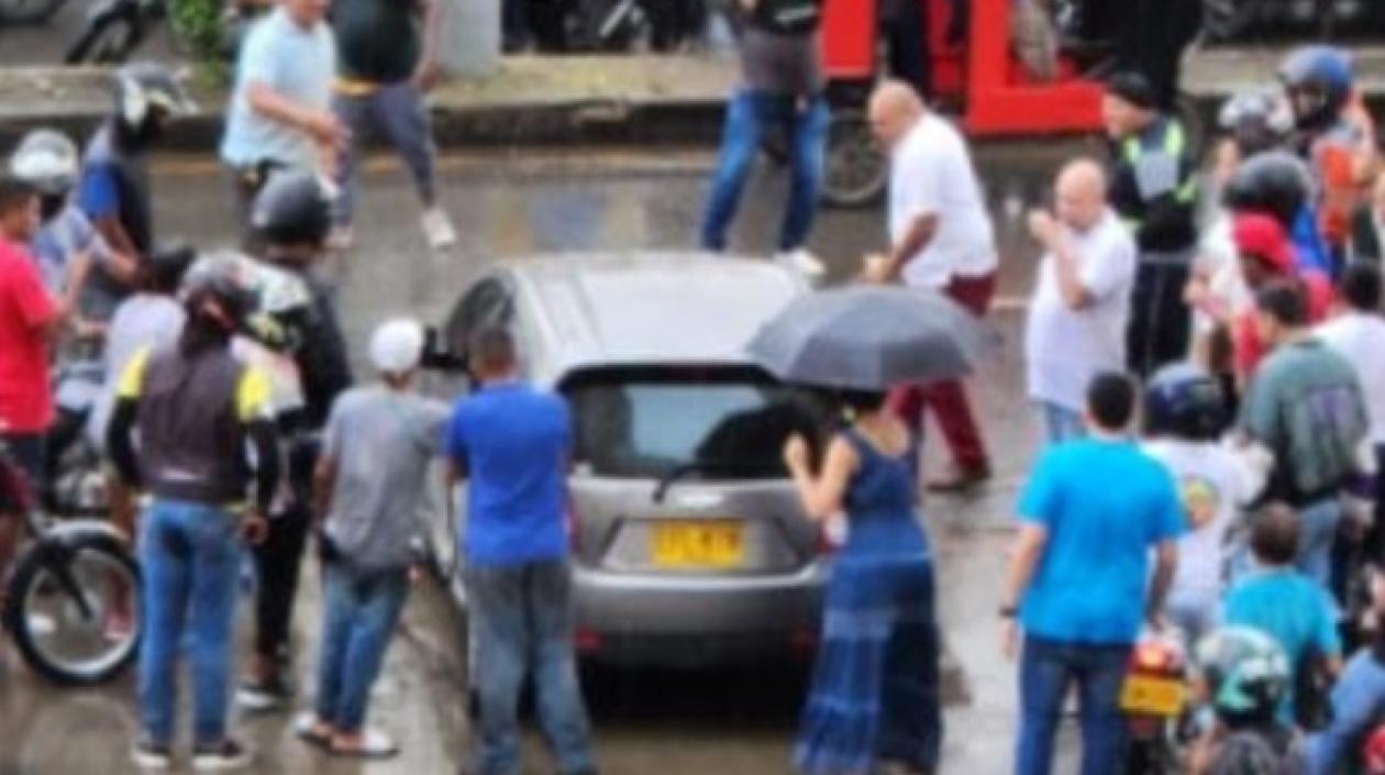 Curiosos rodean el vehículo en el que se desplazaba la mujer baleada.