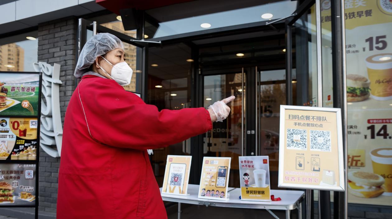 Puesto de información sobre el coronavirus en el exterior de un restaurante en Pekín