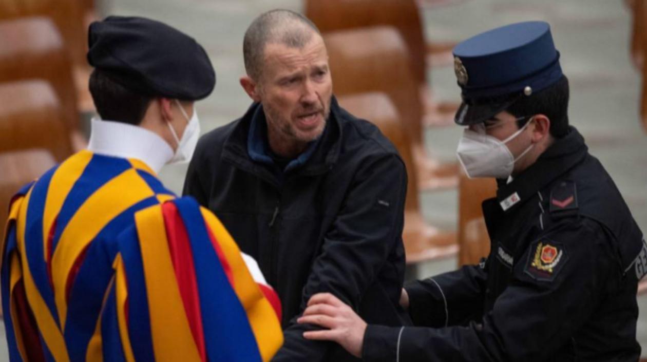 El hombre es escoltado por dos agentes después de increpar al papa Francisco.