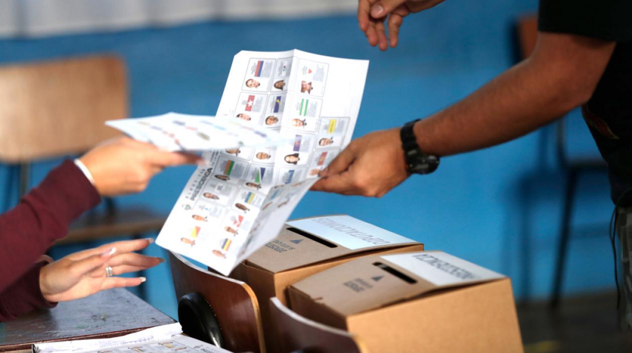 Un ciudadano depositando en la urna el tarjetón presidencial.