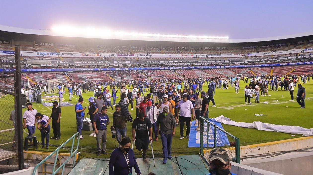 Hinchas abandonan la cancha del estadio Corregidora. 