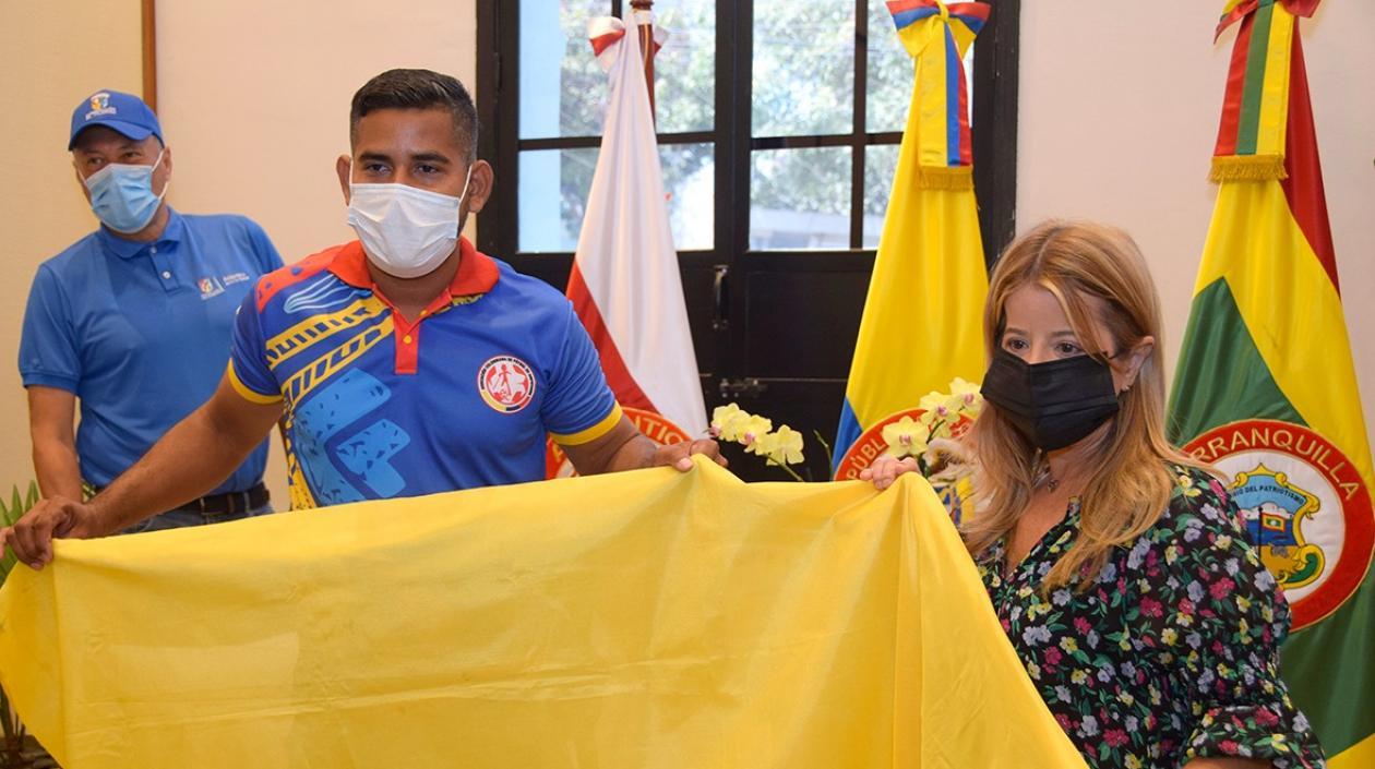 Candelario Donado recibe la bandera de Colombia de la gobernadora Elsa Noguera. 