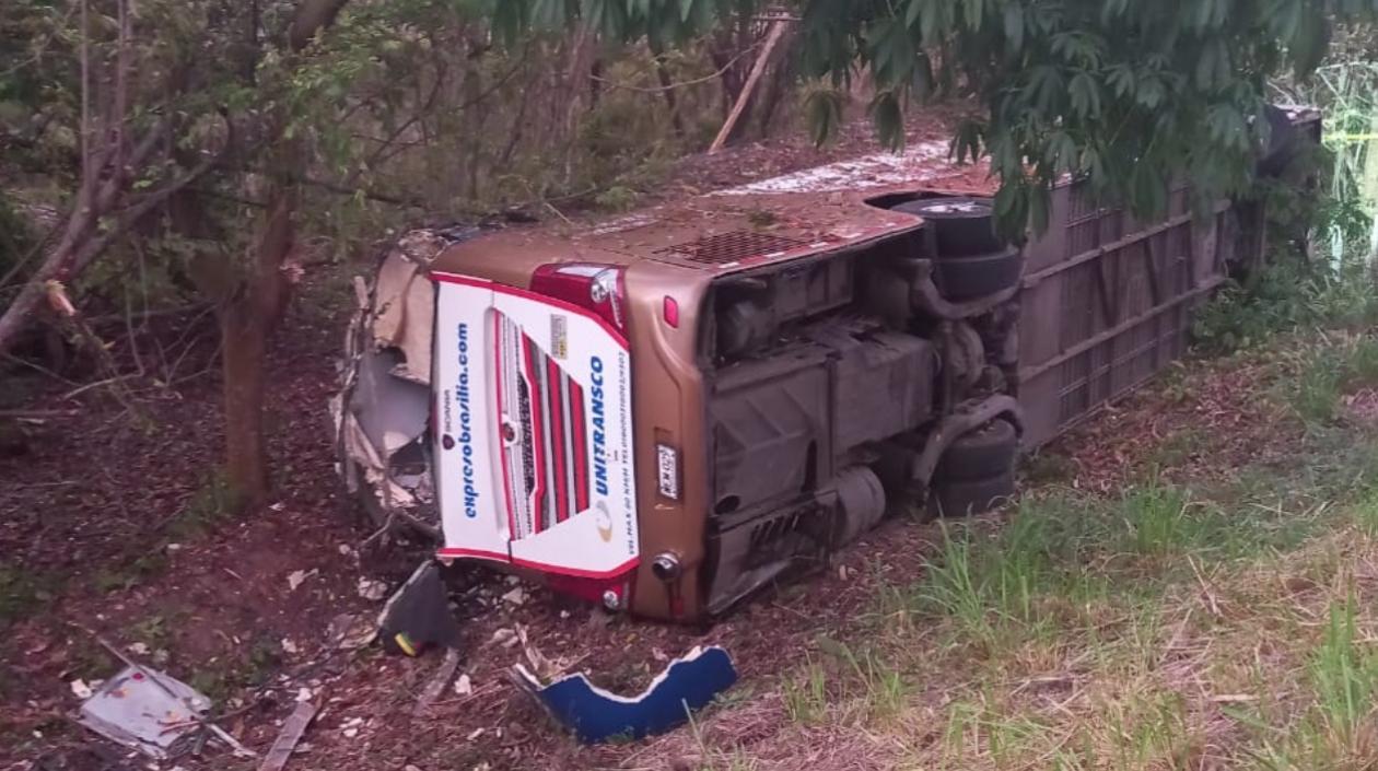 El bus accidentando tras salirse de la carretera. 