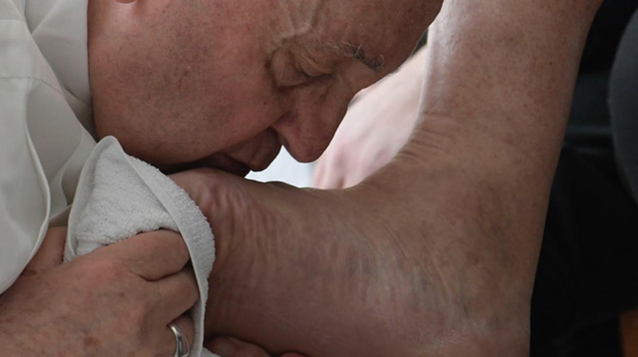 En las únicas tres imágenes difundidas por el Vaticano se ve al Papa arrodillado ante los detenidos.