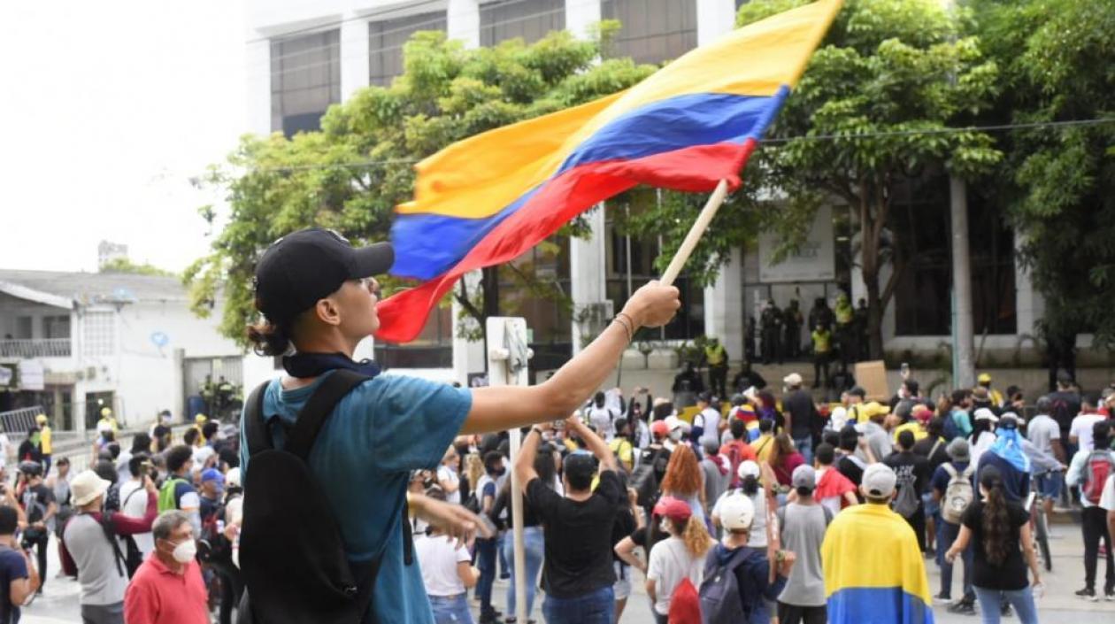 Manifestantes agitando la bandera de Colombia.
